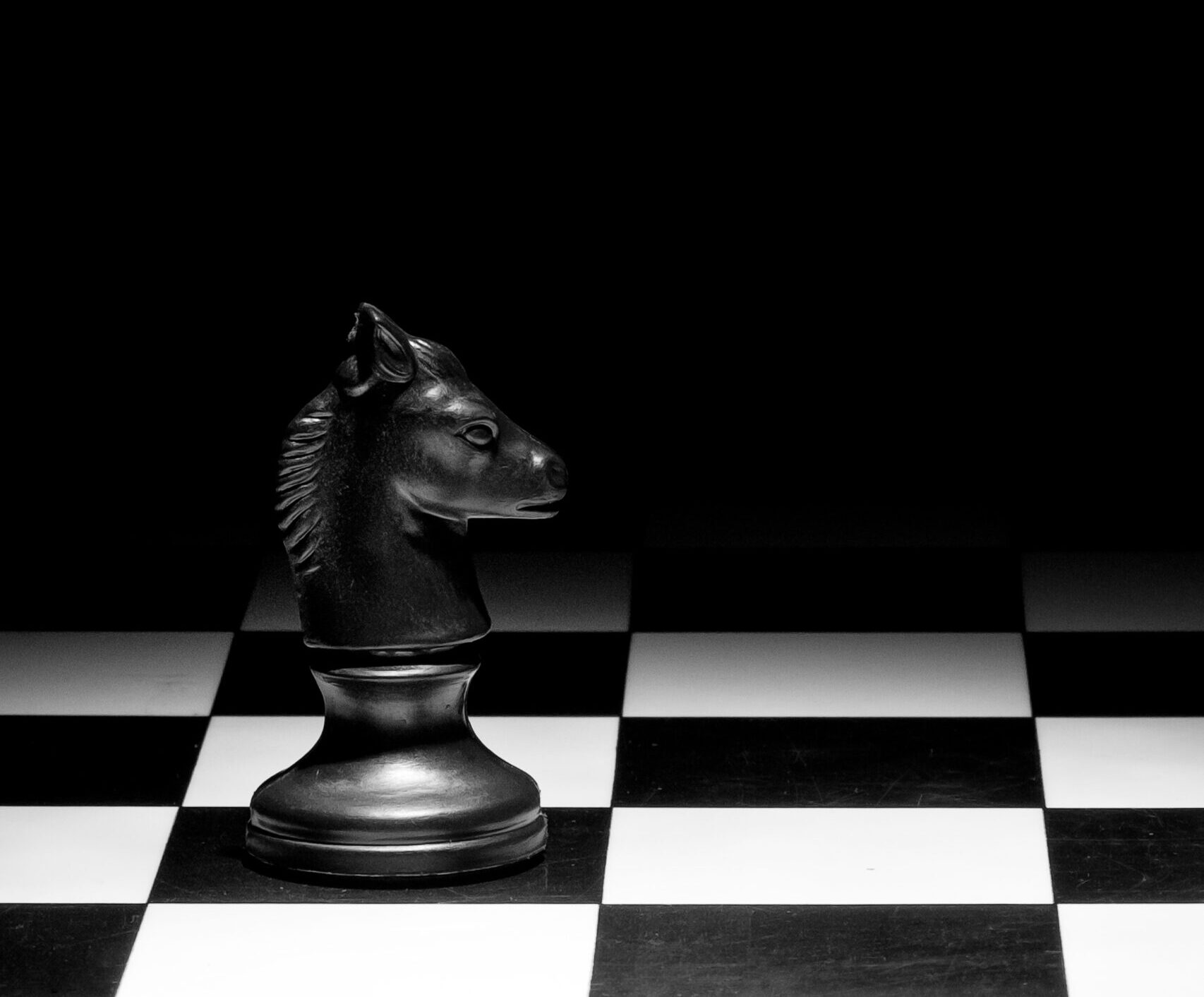 knight chess piece board against black background scaled e1715091624688